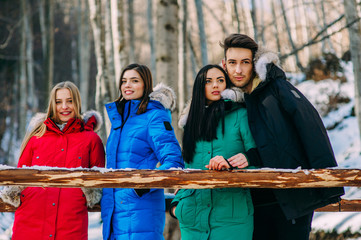 three girls and one boy in the winter forest