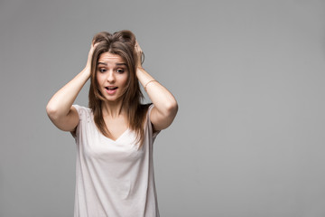 Portrait of beautiful brunette woman with a astonished expression posing in studio on gray background