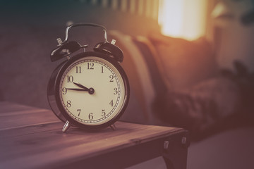 Naklejka premium modern black alarm clock on wooden table side