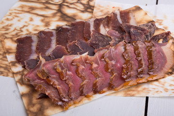 Jerky meat sliced on wooden board