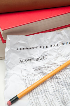 crumpled omr answer sheet and books on white backgrounds