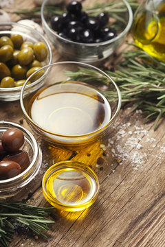 Olive oil  with olives mix  on the wooden table  vertical