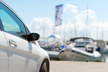 Car parked near next to the pier with boats.