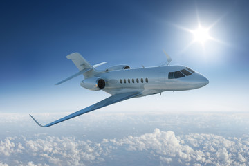 Private jet  flying above the clouds with the sun in blue sky - obrazy, fototapety, plakaty