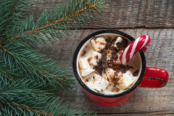 Christmas drink. Hot chocolate with marshmallows and candy cane on the wooden background. Hot cocoa with marshmallows. New Year. Holiday card. Rustic style. Close up.