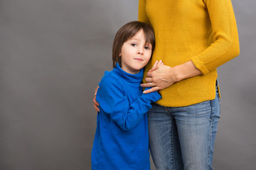 Sad little child, boy, hugging his mother at home, isolated imag