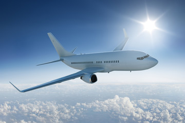 Airliner flying above the clouds with the sun in blue sky - obrazy, fototapety, plakaty