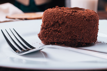Chocolate cake and fork on a white plate