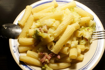 piatto di maccheroni con cavolfiore verde, pancetta e formaggio