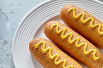Corn dog American corndog street food fried hotdog meat sausage with mustard snack treat coated in...