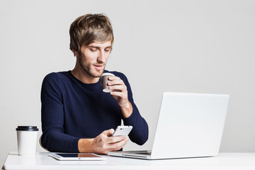 Portrait of a young business man working with laptop computer and drinking coffee
