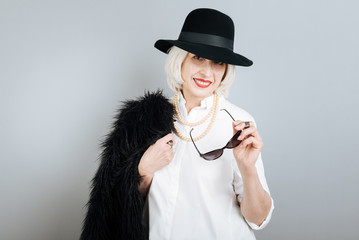 Smiling fashionable woman holding glasses.