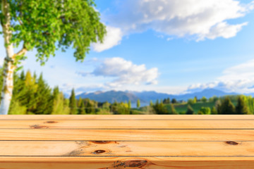 Obraz premium Wooden board empty table in front of blurred background. Perspective brown wood table over blur mountain landscape background - can be used mock up for display or montage your products.