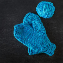 Handmade child's mitts with a ball of yarn.