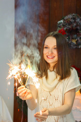 The girl at the Christmas tree with sparklers