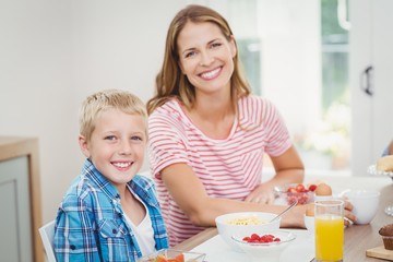 Obraz na płótnie Canvas Happy mother and son having breakfast