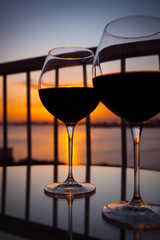 Two glasses with red wine in sunset