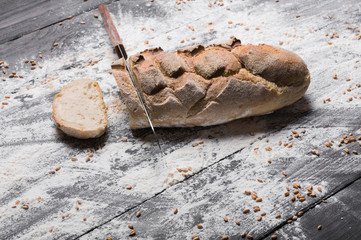 Bakery concept background. Knife cutting bread loaf slices