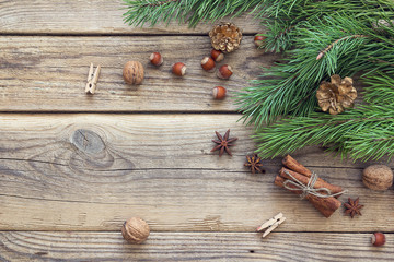 Obraz na płótnie Canvas Christmas background with pine branches, nuts, cinnamon sticks a