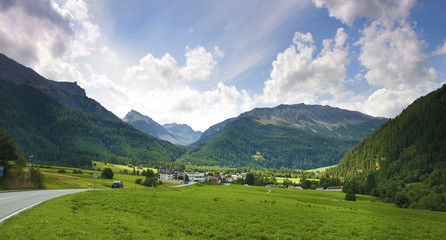 Fototapeta na wymiar road across green meadows. Swiss