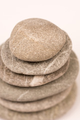 Balanced grey stones over white background with copy space