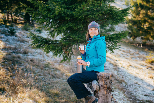 Woman in bright sport clothes is drinking a delicious tea while