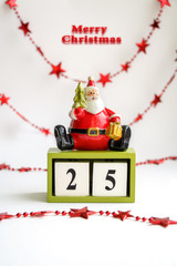 Xmas greeting card with Santa Claus, words Merry Christmas and wooden cubes showing the date 25 of December. Save the date calendar. Vertical image