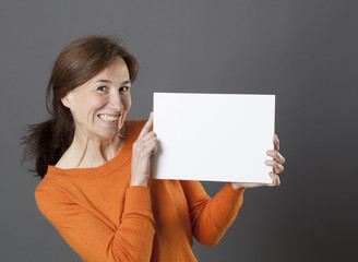 smiling gorgeous middle aged woman holding white fun marketing panel