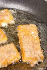Frying fried yellow cheese with eggs in frying pan