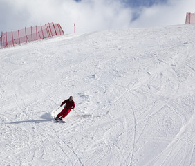 Skier on ski slope at sun day