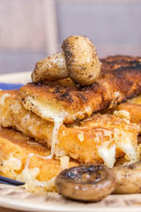 Fried mushroom with fried yellow cheese on eggs