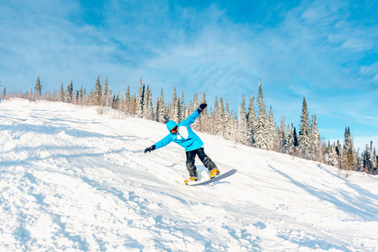 Snowboarder doing a toe side carve with deep blue sky in background