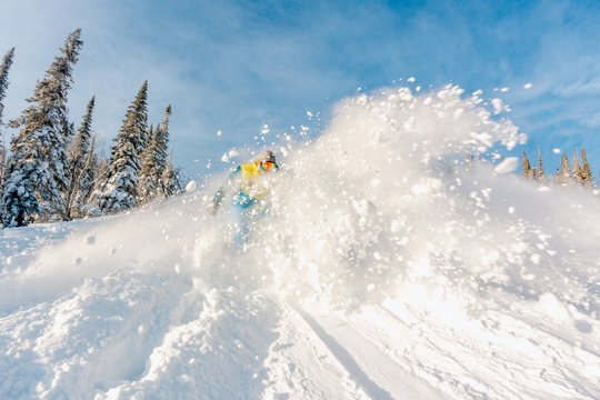 Snowboarder in winter sports gear riding down the slope at a ski resort