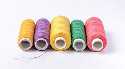 Colorful bobbin thread on white background