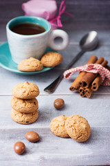 Сup of coffee and a long spoon with oatmeal cookies, a jar of j