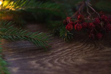 Christmas-tree branch and berries on a wooden background