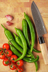 fresh vegetables on the cutting board and knife : garlic, cherry