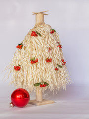 White wood shavings Christmas tree with red berries and one big red ornament