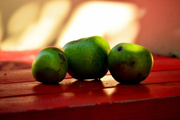 GREEN APPLES ON RED TABLE