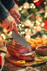 Young woman carving glazed holiday ham