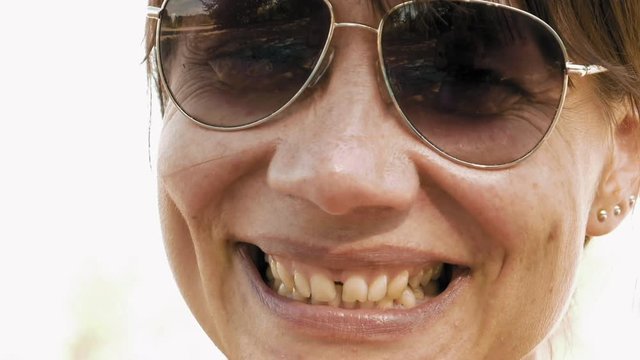 Woman is laughing expressively and emotionally. Hoots of laughter is a permanent attribute of enjoying a good company and relaxation outdoors. Positive emotions and happiness concept.