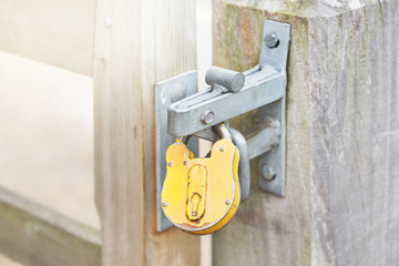 Yellow padlock on a closed gates