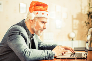Modern Santa Claus orders Christmas gifts or hr-manager is plann
