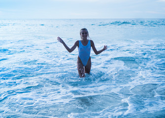 Woman wearing white swimsuit smiling  in sea water. Summertime concept