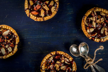 Mini tarts with nuts and caramel on a rustic background, top view, copy space