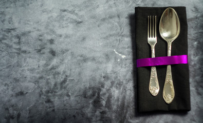 Rustic vintage set of cutlery spoon, fork. Dark background. Top view