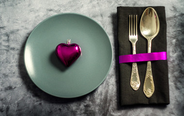 love heart in dish, fork and spoon on table