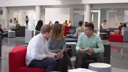 Student group studying together in a modern university lobby, shot on R3D