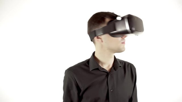 Man wearing virtual reality goggles. Studio video, white background