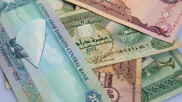 Arab money UAE dirhams on rotating surface background